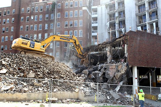 The Sentinel-Record/Richard Rasmussen BRICK BY BRICK: An hydraulic excavator tears down the north end of the parking deck under the Lanai Suites Monday. The city said demolition contractor DT Specialized Services Inc. is ahead of schedule and plans to begin tearing down the Lanai Suites next week.