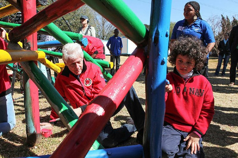 Former President Bill Clinton helps paint a jungle gym in August 2013 during a visit to a Clinton Foundation project in Johannesburg, South Africa. “The work of the foundation is as important to him as anything he’s ever done in a lifetime of public service,” said Matt McKenna, who worked as Clinton’s spokesman until last year. 