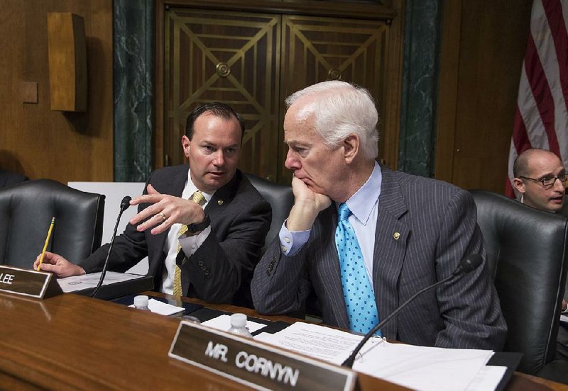 Sen. Mike Lee (left), R-Utah, confers with Sen. John Cornyn, R-Texas, on Capitol Hill in Washington in this March 16 photo. 