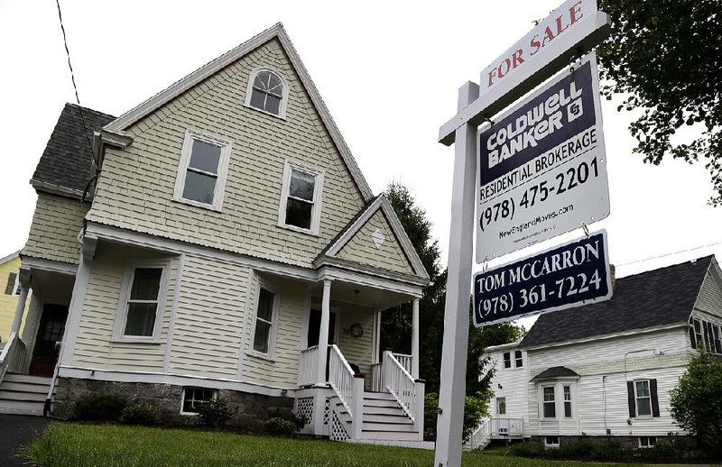 A sale sign marks a house on the market in Andover, Mass., in this May file photo. A measure of U.S. home prices based on a 20-city survey rose in June. 