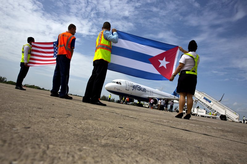 Airport workers receive the JetBlue flight 387 holding a United States, and Cuban national flag, on the airport tarmac in Santa Clara, Cuba, Wednesday, Aug. 31, 2016. JetBlue 387, the first commercial flight between the U.S. and Cuba in more than a half century, landed in the central city of Santa Clara on Wednesday morning, re-establishing regular air service severed at the height of the Cold War. (AP Photo/Ramon Espinosa)
