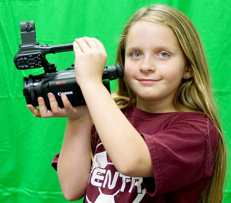 Samantha Hillis, third-grade student at Gentry Intermediate School, looks at a Canon video camera the school district received as a part of its new EAST Initiative grant for the elementary schools. Students were unpacking and assembling items received as a part of the grant and putting them away in the classroom last Wednesday. Students who participate in the EAST Initiative use the technology provided to complete community projects developed by the students.