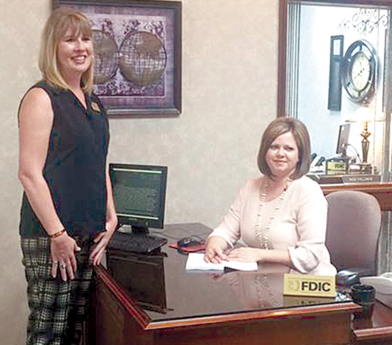 Sundee Hendren, left, vice-president at the Bank of Gravett, poses with Gravette author Sherri Beth Johnson as she waits for her to sign a copy of her new book, “Georgiana.” Johnson held a book signing at the bank Aug. 16. “Georgiana” is the first of a series of Christian romances.