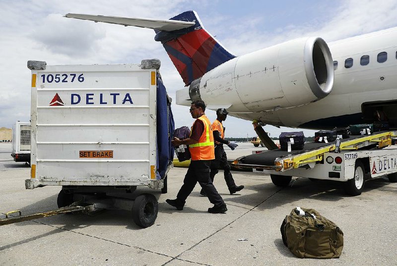 Workers unload bags from a Delta Air Lines jet at Baltimore-Washington International Thurgood Marshall Airport in Linthicum, Md., in July. The airline is installing a new system that uses radiofrequency identification chips in luggage tags.