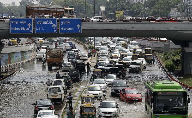 Flooding from monsoon downpours slows traffic Wednesday in New Delhi. Secretary of State John Kerry’s motorcade struggled to navigate streets in water nearly knee-deep. 