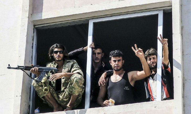 Members of Free Syrian Army (left photo) relax Wednesday in Jarablus in northern Syria days after their forces captured the town with the help of Turkish forces. 