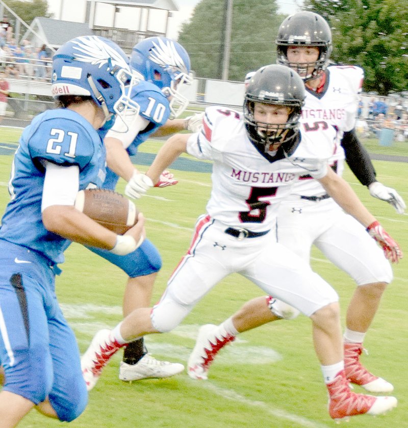 Photo by Rick Peck McDonald County&#8217;s Marshall Foreman eyes Marshfield&#8217;s Wyatt Wilsey before stopping the Blue Jay running back for a short gain during the Mustangs&#8217; 28-6 loss Friday night in Marshfield.