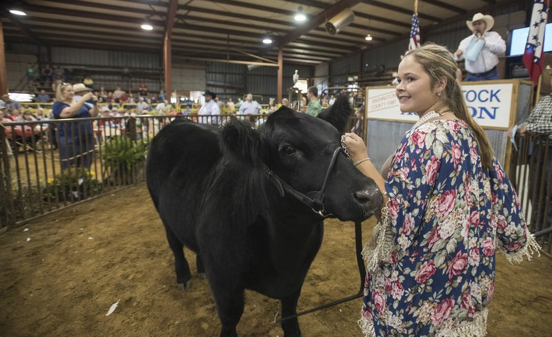Jessika Calhoon of Farmington smiles Thursday as people bid on her champion Maine-Anjou named Elsa during the auction at the Washington County Fair in Fayetteville.