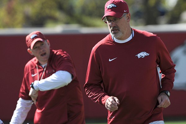 Arkansas assistant coach Paul Rhoads (right) speaks with his players alongside defensive coordinator Robb Smith Thursday, March 31, 2016, during practice at the university's practice field on campus in Fayetteville.