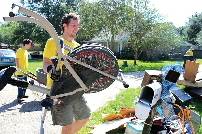 Mormon Helping Hands volunteer Nathan Wood, right, a Brigham Young University-Idaho student from Batesville, and Rocko Woods of Mountain View place belongings on the street.