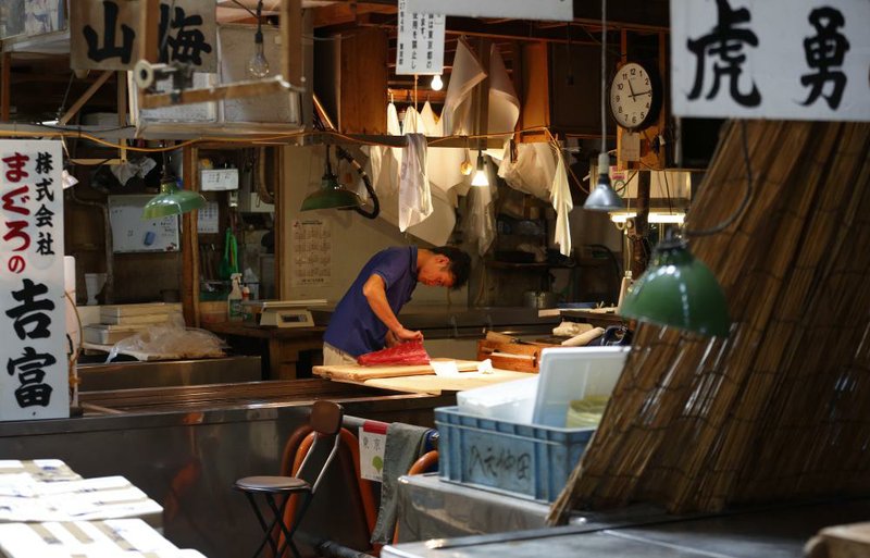 A fishmonger checks a tuna at the Tsukiji fi sh market in Tokyo last week.