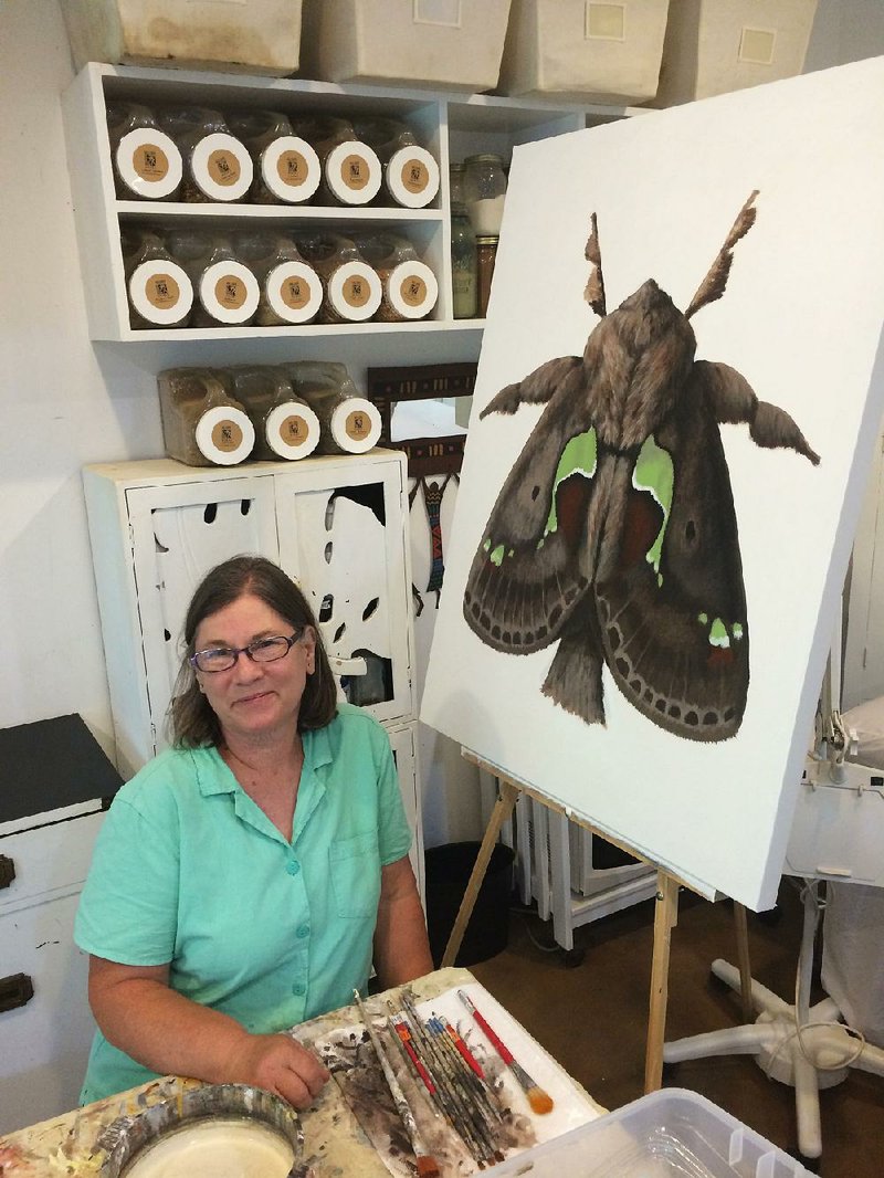 Deborah Davis, a gardener and artist living near North Garden, Va., has turned her gaze to the butterfl y’s poor relations, moths. She is shown here with her latest work, depicting a spiny oak-slug moth. In nature it’s only an inch across.
