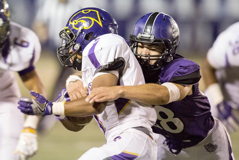 Blue Springs (Mo.) junior running back Michael Warmack (left) is stopped Friday by Fayetteville senior linebacker Nick Scalise at Harmon Field.