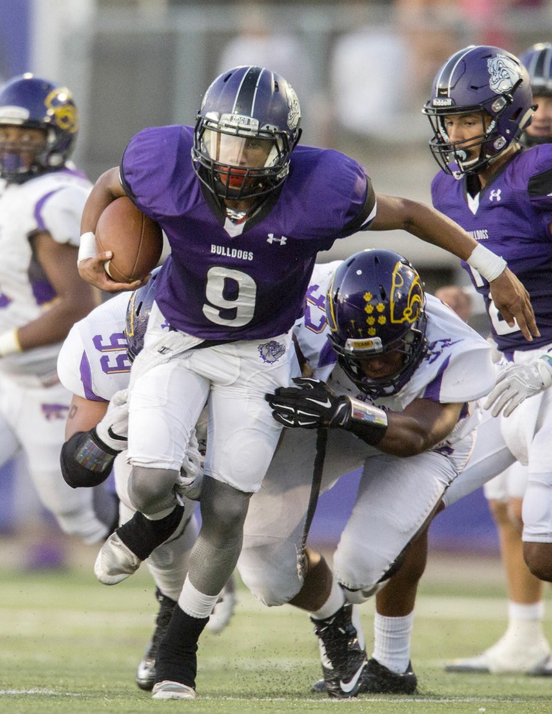 NWA Democrat-Gazette/JASON IVESTER Fayetteville senior running back Rock Terrance breaks through the line against Blue Springs (Mo.) at Harmon Field.