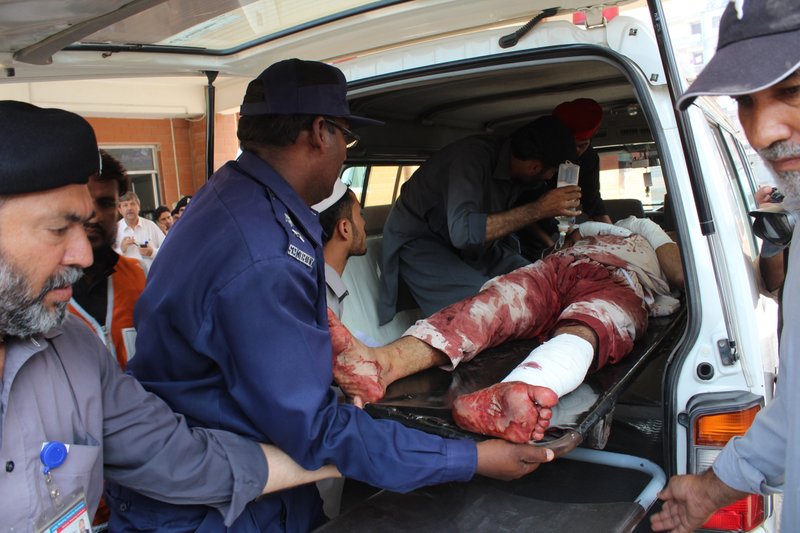 Pakistani volunteers carry an injured person who arrived from Mardan, at a local hospital in Peshawar, Pakistan, Friday, Sept. 2, 2016. 