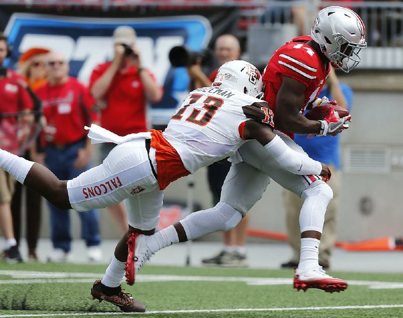 Ohio State wide receiver K.J. Hill (North Little Rock) eludes Bowling Green defensive back Jamari Bazeman on a 47-yard touchdown pass during the fi rst quarter of the No. 6 Buckeyes’ 77-10 victory Saturday in Columbus, Ohio.
