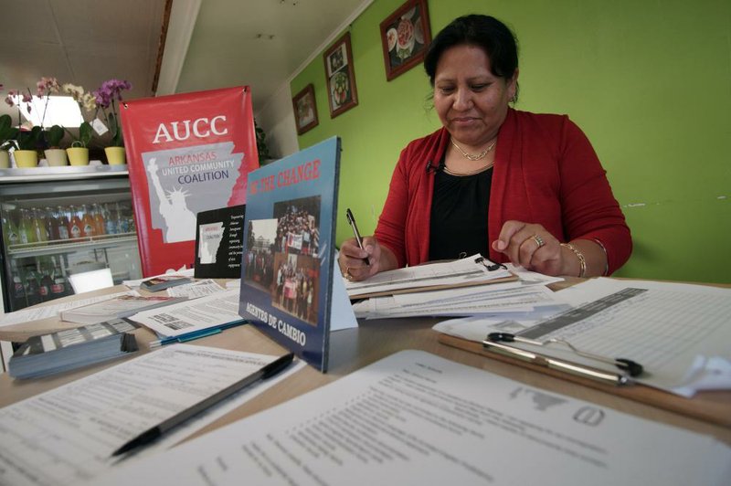 Arkansas United Community Coalition organizer Leticia Reta fills out paperwork Thursday as she waits to register voters at the Neveria Tino restaurant in Little Rock.