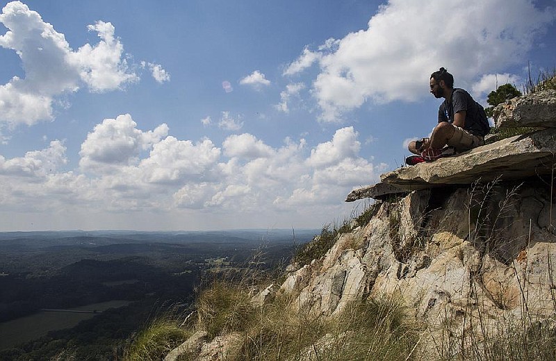 Sunny Harshdeep eats lunch from a spot atop Pinnacle Mountain as he looks into the surrounding valley from the summit in this Sept. 5, 2016, file photo. Hundreds of visitors hiked the trails that Monday during the Labor Day holiday. (Arkansas Democrat-Gazette file photo)