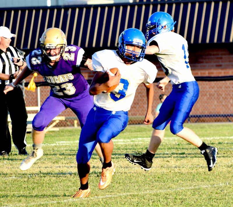 Photo by Mike Eckels On the opening possession for Decatur, Jimmy Mendoza (Decatur 3) slipping pass Jacob Johnson (Berryville 23), finds open ground and heads into the end zone for a touchdown during the Bobcat-Bulldogs football game at Ronnie Clark Field in Berryville Sept. 2. A Decatur penalty called the play back canceling the touchdown.
