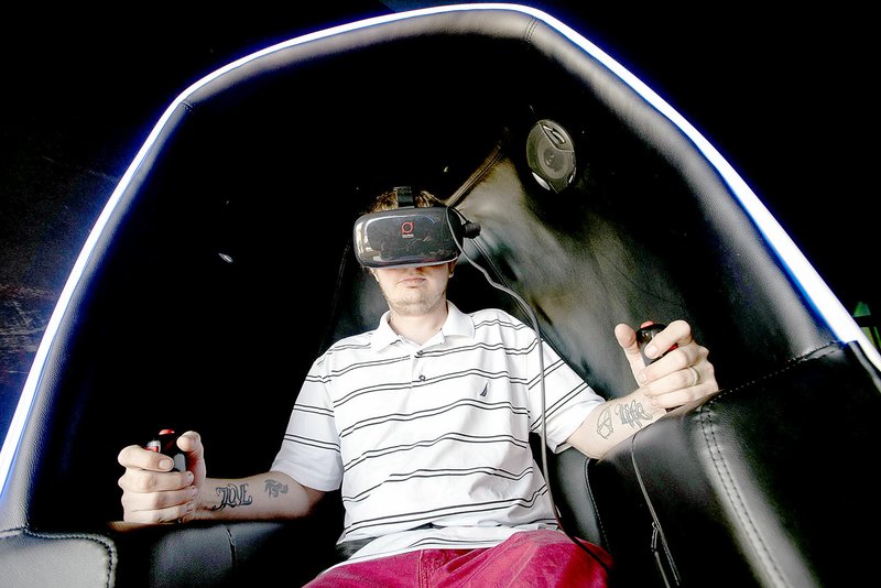 J.T. Wampler/NWA Democrat-Gazette Dustin McVay of Seligman, Mo., takes a virtual roller coaster ride Aug. 21 while participating in the Virtual Reality Olympics at Virtual Game World &amp; Event Center in Rogers. The business is owned by Bella Vista resident Juergen Lottman.