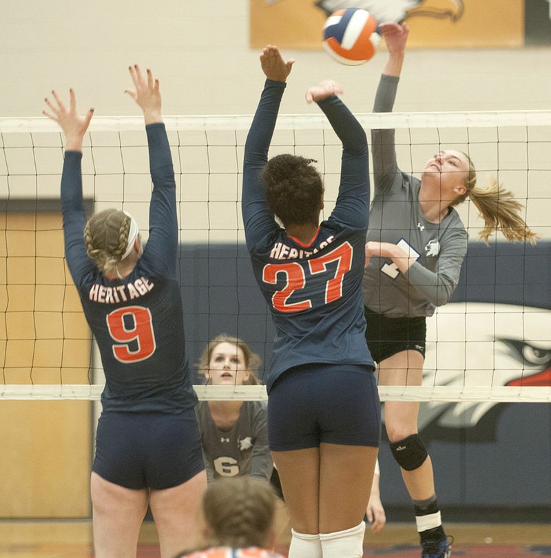 Rogers High School’s Cassidy Wall (right) tries to get the ball past Rogers Heritage’s C.J. Landmark (9) and Brooklyn Head on Tuesday at Heritage.