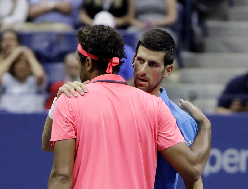 Novak Djokovic, of Serbia, talks with Jo-Wilfried Tsonga, of France, after Tsonga retired from the match in the quarterfinals of the U.S. Open tennis tournament, Tuesday, Sept. 6, 2016, in New York.