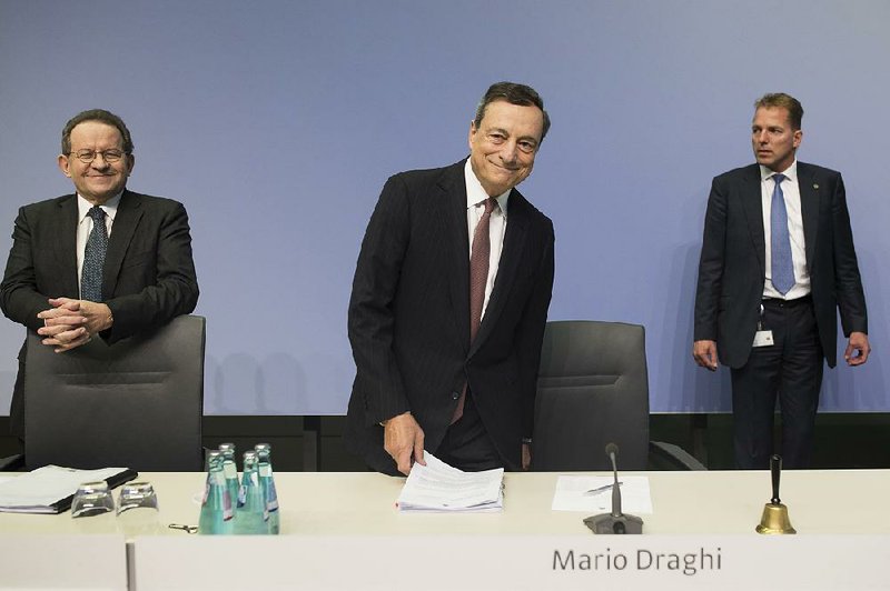 Mario Draghi, president of the European Central Bank (center), and Vitor Constancio, the central bank’s vice president (left), arrive Thursday for a news conference in Frankfurt, Germany.