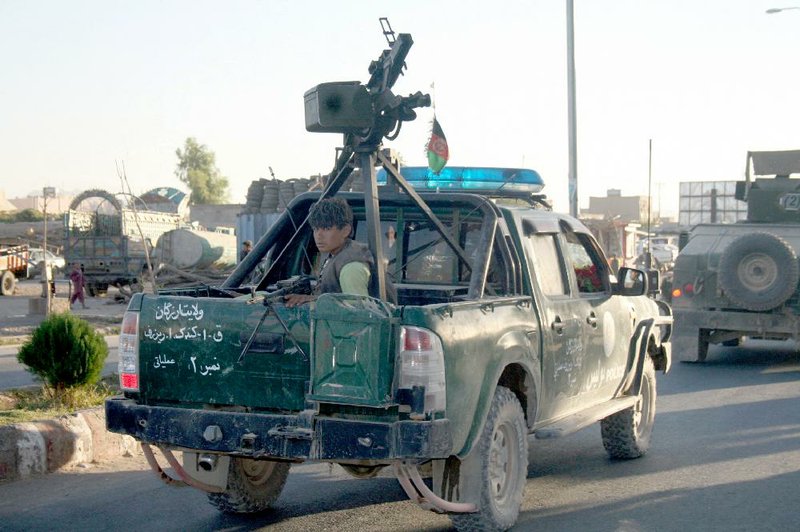 An Afghan policeman travels Thursday in Uruzgan province’s capital, Tirin Kot, which reportedly has been overrun by the Taliban.