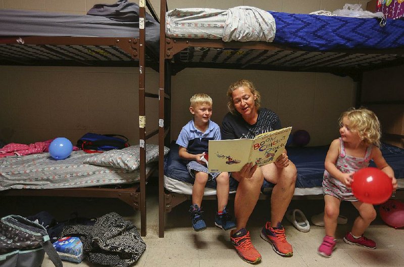 Shannon Tate reads to two of her five kids at the Salvation Army in Little Rock. The living space is part of a new women and family shelter in an area formerly reserved for men. The Salvation Army announced the implementation of a new Pathway of Hope initiative to help underserved families break their cycle of poverty.