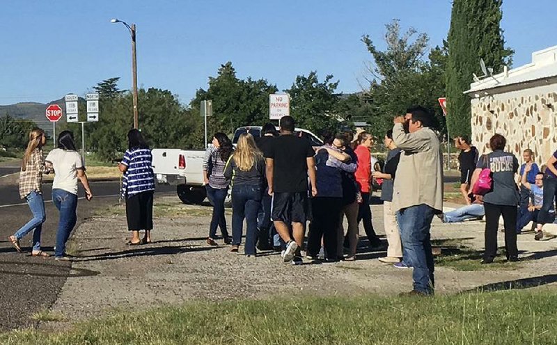 People gather near the Alpine High School campus after a shooting Thursday in Alpine, Texas.