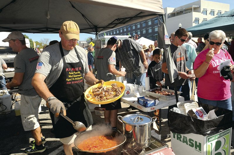 Jeff Pollock of Rogers adds smoked squirrel pieces to his team's dish during the third annual World Championship Squirrel Cookoff in downtown Bentonville in 2015.