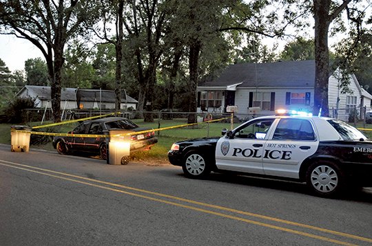 The Sentinel-Record/Mara Kuhn CRIME SCENE: Hot Springs police units are seen outside a residence at 311 Lacey St. where five people were reportedly shot shortly before 7 p.m. Thursday in a confrontation that occurred in a gravel driveway between 311 and 315 Lacey. A black four-door sedan, left, was reportedly driven by some of the people involved in the confrontation, who fled the scene.