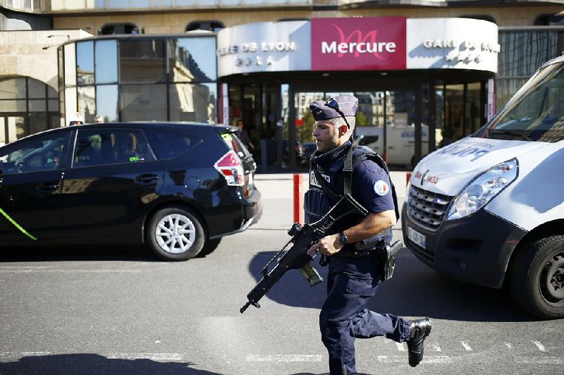 A police officer takes position during a bomb scare Friday at a railway station in Paris, where security was heightened during an investigation of an Islamic State-inspired plot that was foiled. 