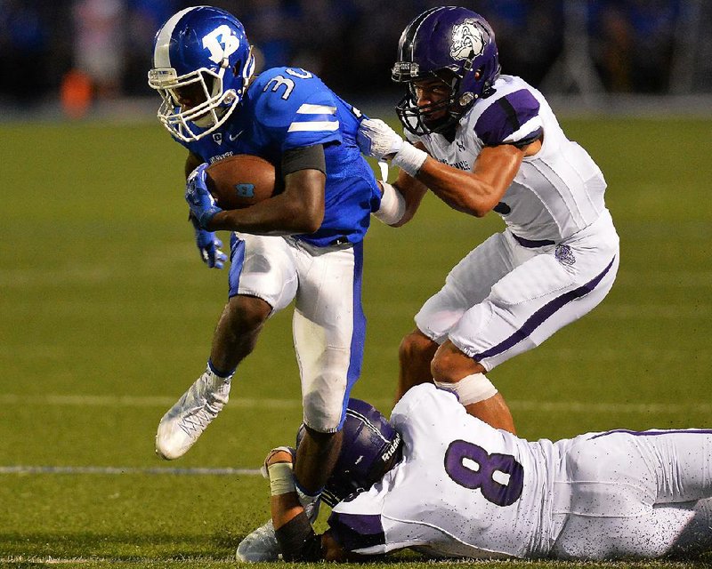 Bryant running back Jeremiah Long (left) is brought down by Fayetteville’s Trey Colter and Blake Coulter (8) during Friday night’s game at Bryant.