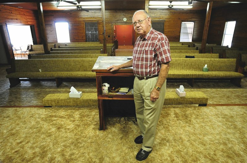 Eldon Bagwell, pastor of Mount Zion Free Will Baptist Church, stands at the pulpit of his church in 2013. The interior walls of the church are beadboard, original to the building.