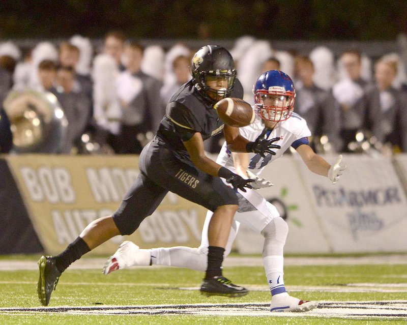 Bentonville cornerback Jadyn Loudermilk (left) intercepts a pass intended for Eric Calton-Watkins of Bixby, Okla., in the second quarter Friday at Tiger Stadium in Bentonville.