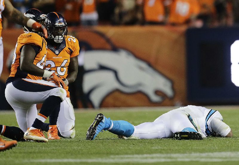 Carolina Panthers quarterback Cam Newton (right) was the victim of several hits from the Denver Broncos defense Thursday night. Many of those, says Rick Gosselin of The Dallas Morning News, should have drawn flags. 