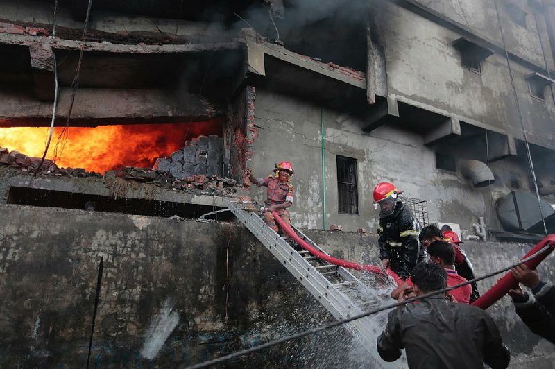 Firefighters work Saturday to extinguish a blaze at a five-story packaging factory outside Dhaka, Bangladesh.