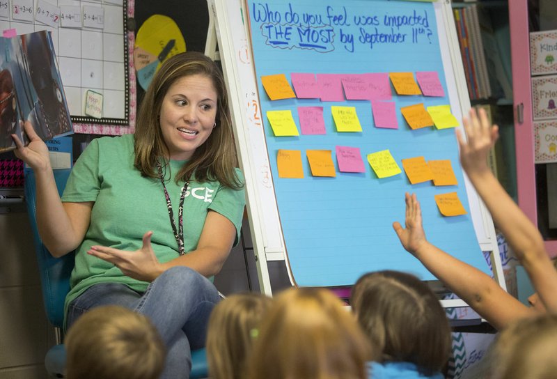 Dawn Patafie, Sugar Creek Elementary School third-grade teacher, reads 14 Cows for America on Friday to her class at the Bentonville school. Patafie, who is from New York, was leading a lesson on the 9/11 attacks to her class.