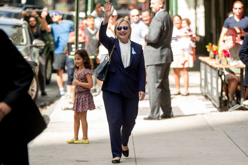 Democratic presidential candidate Hillary Clinton waves after leaving an apartment building Sunday  in New York. Clinton's campaign said the Democratic presidential nominee left the 9/11 anniversary ceremony in New York early after feeling "overheated."