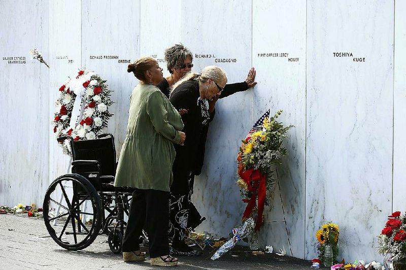 Relatives of victims of the Sept. 11, 2001, terrorist attacks touch the Wall of Names on Sunday at the Flight 93 National Memorial in Shanksville, Pa., after a wreath-laying ceremony marking the 15th anniversary of the attacks.