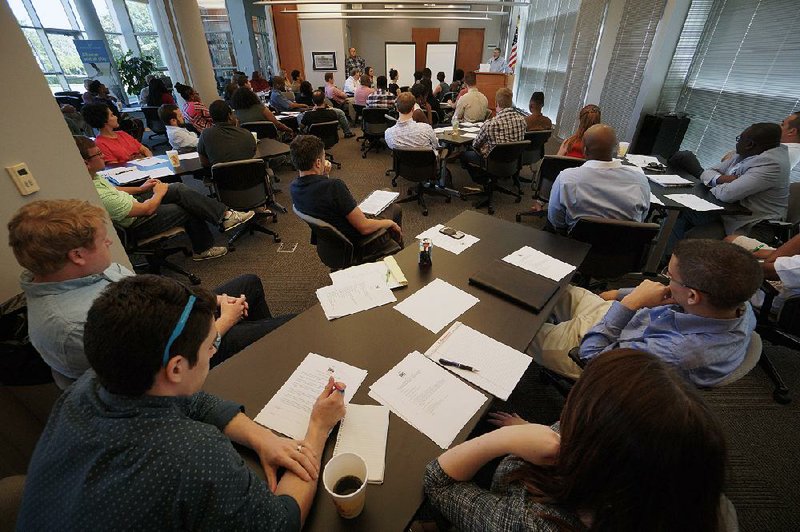 Dean Kumpuris (back right), a member of Fifty for the Future, speaks Sunday during the first session of Think Big Little Rock at the Little Rock Chamber of Commerce.