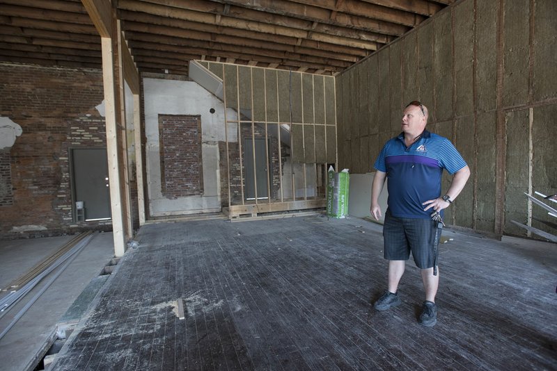 Kevin Nau of Artisan Design shows progress in the Vinson Square property Aug. 30 in Rogers.