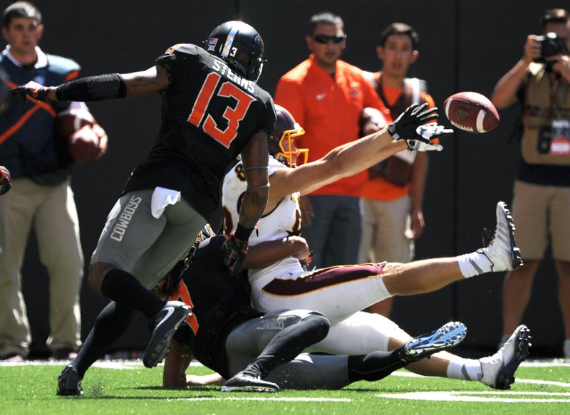 Oklahoma State safety Jordan Sterns, left, watches as Central Michigan wide receiver Jesse Kroll, right, being tackled by Oklahoma State corner back Ramon Richards, bottom, tosses the ball back to Central Michigan wide receiver Cory Willis resulting in a touchdown during the final seconds of an NCAA college football game between in Stillwater, Okla., Saturday, Sept. 10, 2016. Central Michigan won 30-27. 