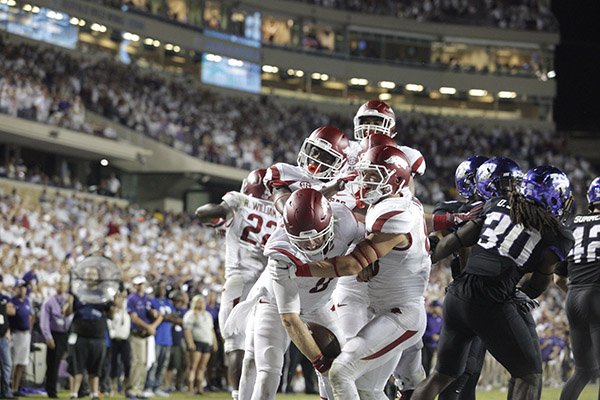 Arkansas quarterback Austin Allen (8) is congratulated by teammates after he scores the game-winning touchdown in the second overtime of a game against TCU on Saturday, Sept. 10, 2016, in Fort Worth, Texas. 