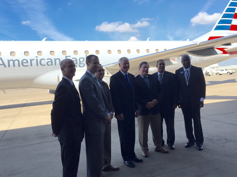 Gov. Asa Hutchinson, flanked by airline representatives and city officials, after a Tuesday, Sept. 13, announcement that Envoy Air is opening an air maintenance facility at Bill and Hillary Clinton National Airport/Adams Field. 