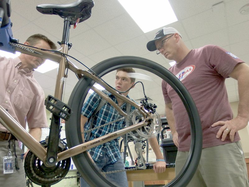 TIMES photograph by Annette Beard Cameronn Power, a junior at Pea Ridge High School, learned about caring for his new mountain bike, an SE, with assistant coach Bobby Rickard, right, and teacher Josh Johnson, left. &#8220;Cameronn just bought this bike and assembled it himself,&#8221; Johnson said. &#8220;We&#8217;re just checking out the chain, the brakes &#8230; getting ready for the race this weekend.&#8221;