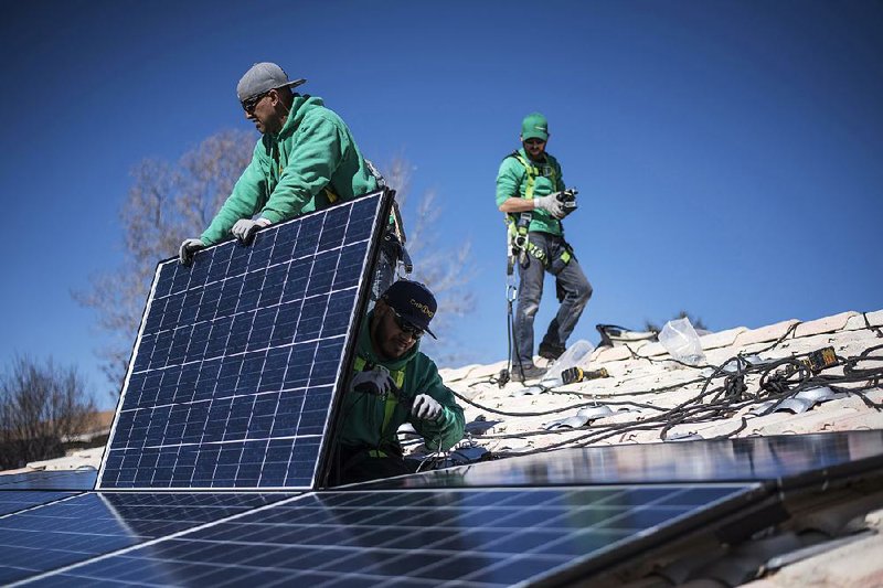 Workers for SolarCity Corp. secure solar panels to the roof of a home in Albuquerque, N.M., in February. Installation of residential solar panels is expected to rise this year but fall flat in 2017. 
