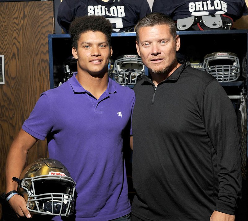 Shiloh Christian defensive coordinator Chris Berus (right) and his son, senior running back and linebacker Broc
Berus pose Wednesday in the team’s locker room in Springdale.