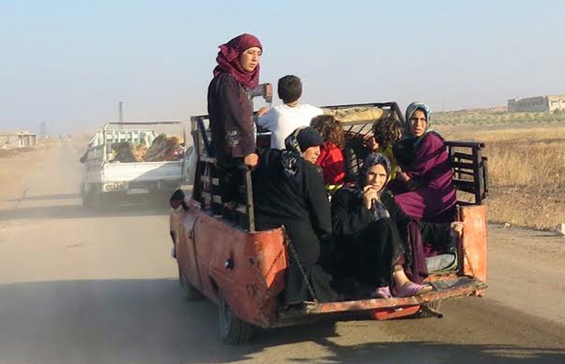 This Thursday Sept. 1, 2016 file photo, provided by the Syria Press Center (SPC), an anti-government media group, shows civilians leaving the town of Suran, in Hama province, Syria.  